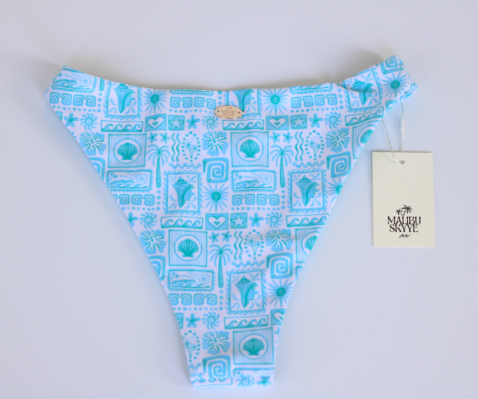Blue and white patterned swim bottom with a brand tag on a light gray background